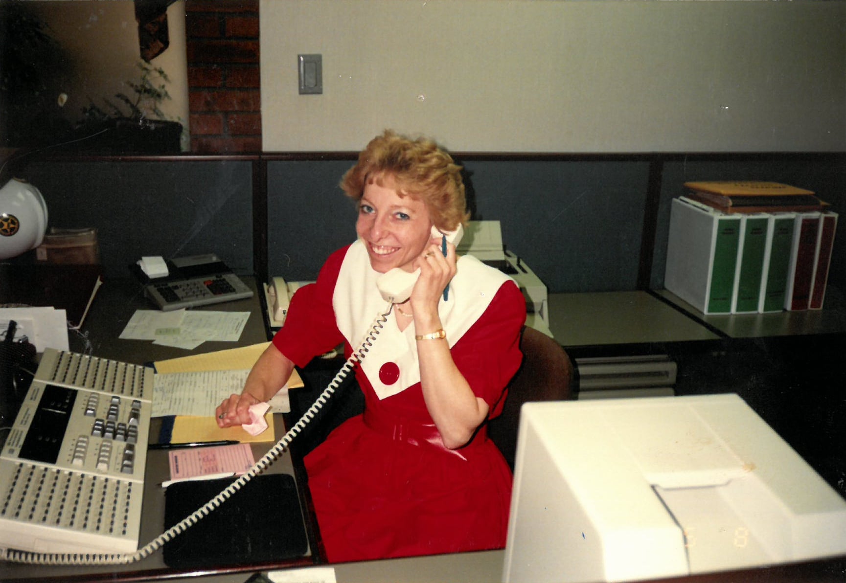 Women in red dress answering phone.