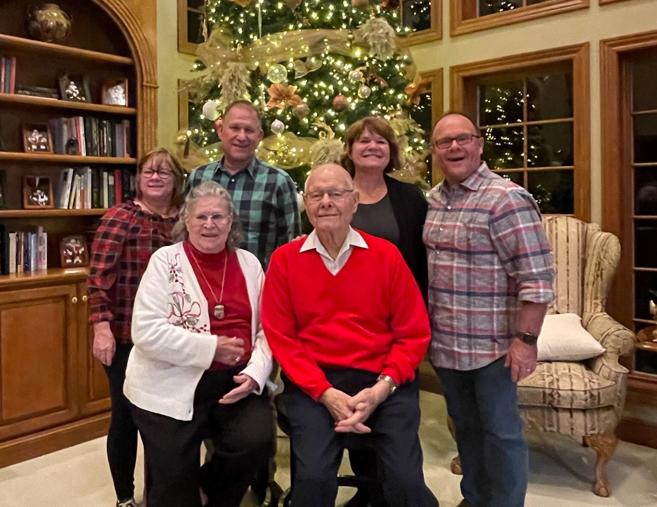 Ralph and Donna Korte with their adult children posing in front of a Christmas tree.