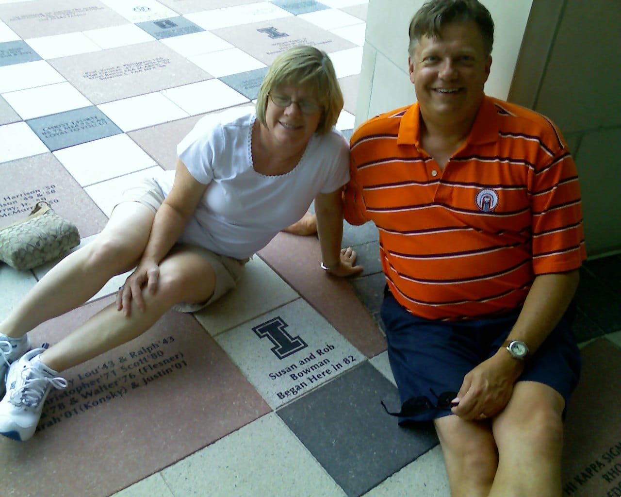 Rob and Susan Korte posing with a university tile where they first met.