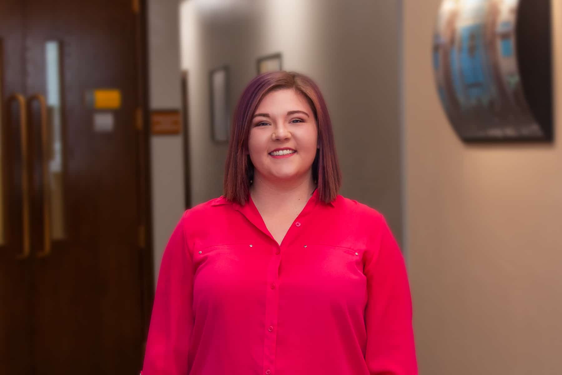 Woman standing in hallway of The Korte Company office, smiling at camera
