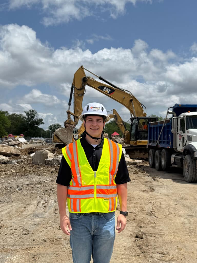 Bradley Prince poses for a photo in front of construction equipment.