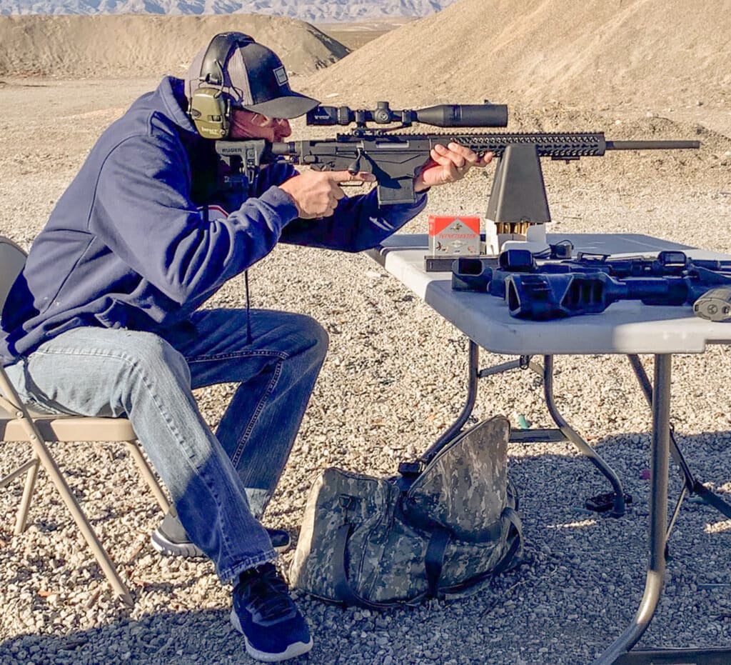 Shawn Erdo looks through the scope of a rifle