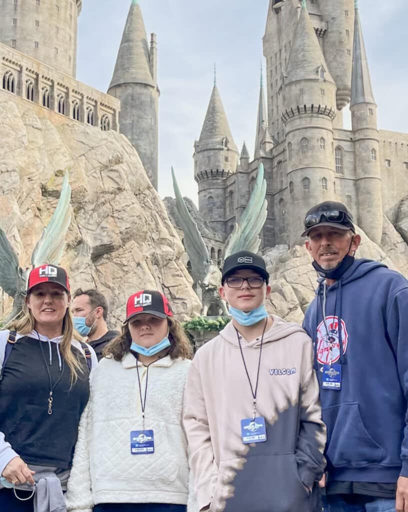 Shawn Erdo and his family pose for a photo with a castle in the background.